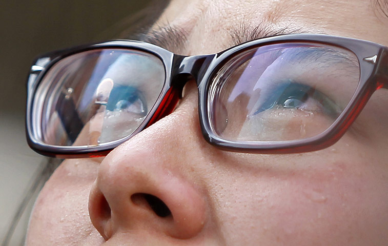 Shanghai Memorial: A woman weeps as she looks at the entrance of a burnt apartment block