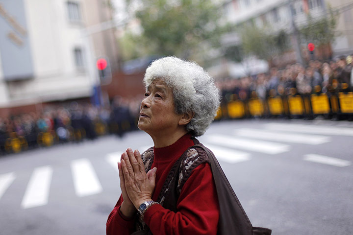 Shanghai Memorial: A mourner prays for victims killed in an apartment block blaze