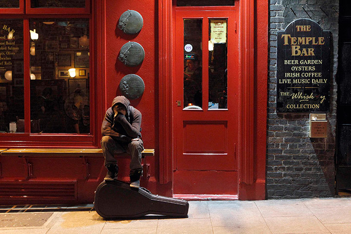 24 hours in pics: A musician sits on a bench outside a pub in Temple Bar, Dublin