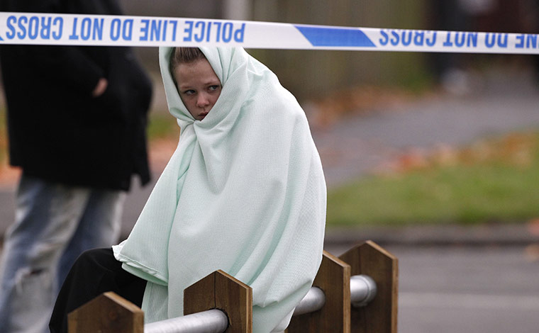 Salford gas explosion: An evacuated resident sits near the scene of a suspected gas explosion