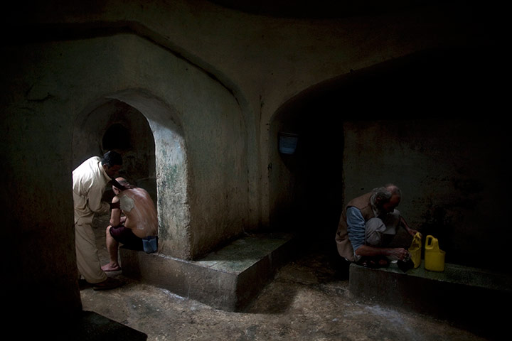 24 hours pics: A man gets help to clean his back in a public bath, Afghanistan