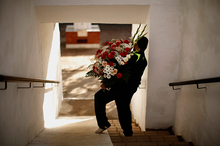 24 hours pics: A man holds flowers to be placed at a tombstone in Ronda