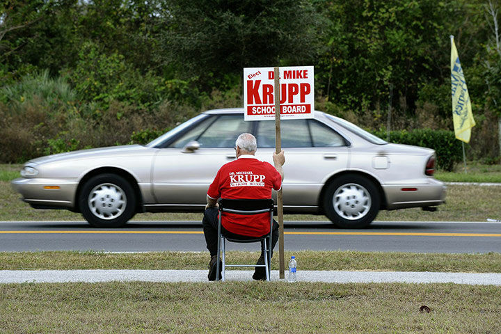 US midterm elections: Titusville, Florida: A volunteer holds up a sign outside a voting location