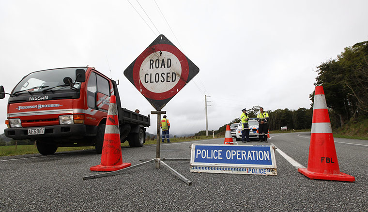 New Zealand mine: New Zealand policemen stand at a road block