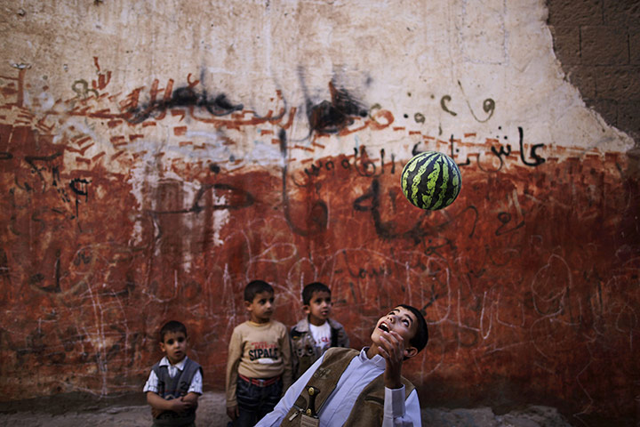 24 hours: Sanaa, Yemen: A Yemeni boy bounces a ball as he plays in an alley