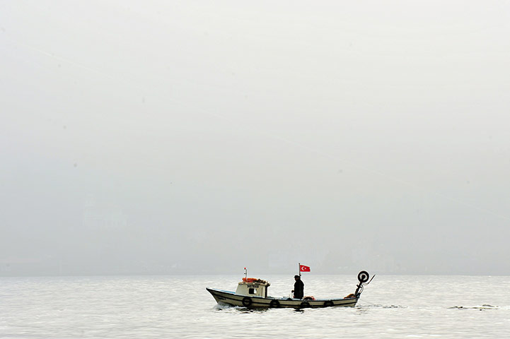 24 hours: Istanbul, Turkey: A fishing boat sails in fog on the Bosphorus 