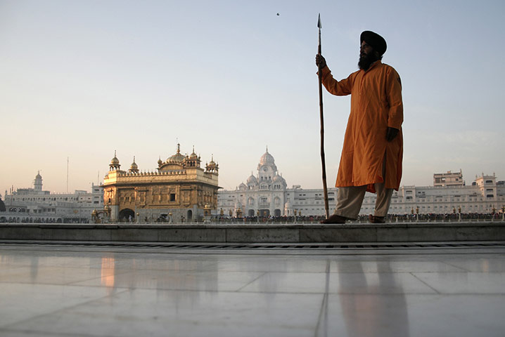 24 hours: Amritsar, India: A Sikh volunteer stands guard at the Golden Temple