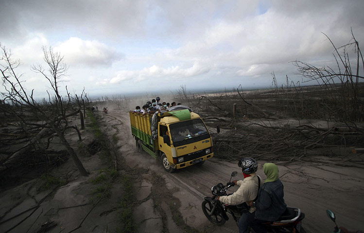 24 hours: Cangkringan, Indonesia: Villagers tour a destroyed village on a truck 