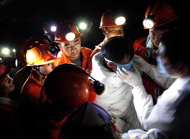 China's trapped miners: A medical worker adjusts an eye cover on a trapped miner