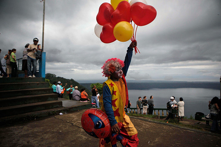 24 hours in pictures: clown sells balloons in nicaragua