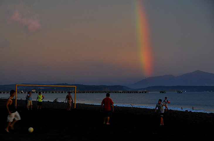 24 hours in pictures: A rainbow is seen as boys play football
