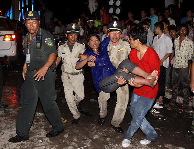 Cambodian stampeded: An injured Cambodian is carried by police