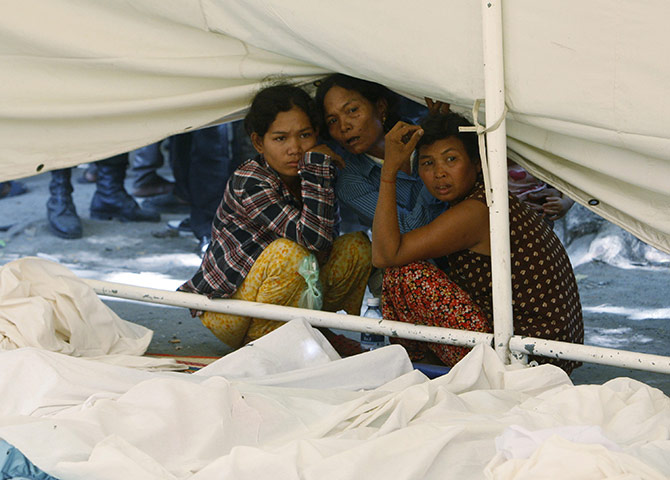 Cambodian stampeded: Relatives sit near the bodies of stampede victims 