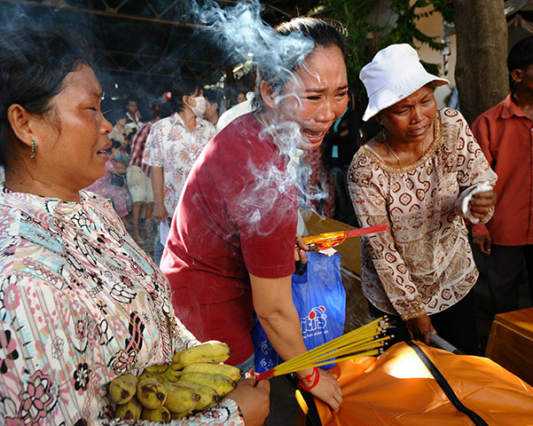 Cambodian stampeded: Women cry as they prepare to carry home the body of their loved one