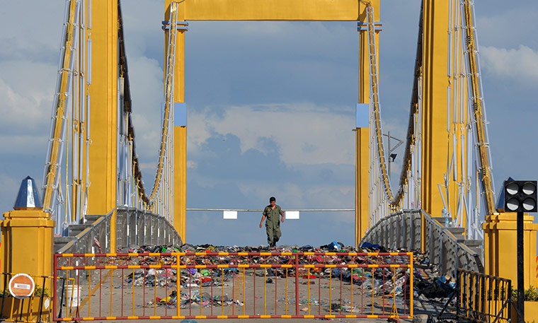Cambodian stampeded 1: A policeman walks among clothes