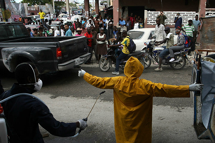 Haiti Cholera: A health worker is disinfected in Port-au-Prince
