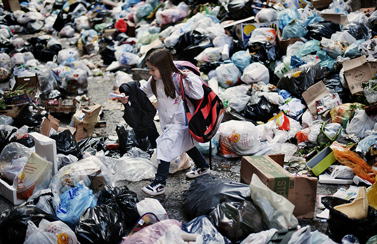 24 hours in pics: A child walks through uncollected garbage in Spain