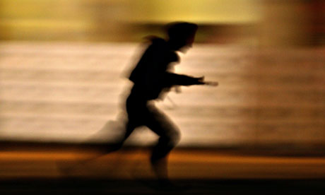 An Indian soldier runs to take a position in Mumbai during the November attack