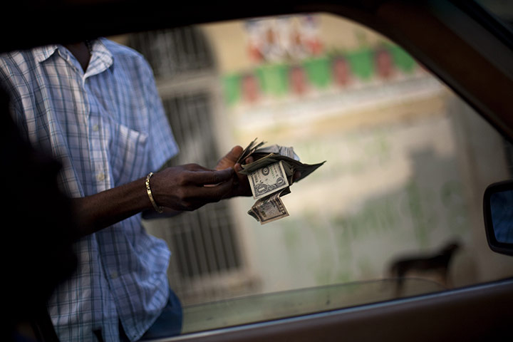 24 hours in pictures: A man changes Haitian Gourdes for US dollars