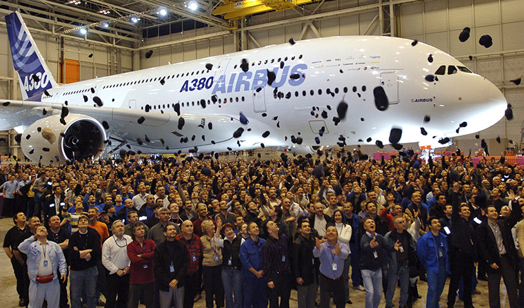 Business Week in Pictures: Airbus employees throw their caps next to the new Airbus A380