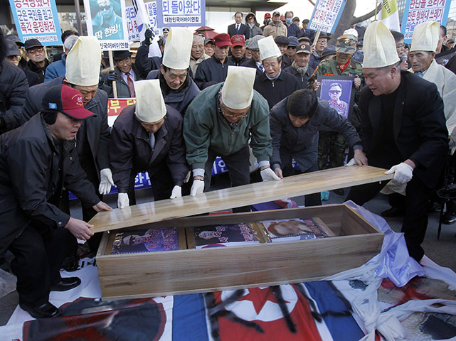 North Korea Update: Protesters open a mock coffin for North Korea's leader Kim Jong-il and son