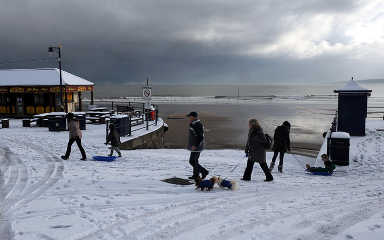 Weather Update: People walk on the beach in Filey, North Yorkshire