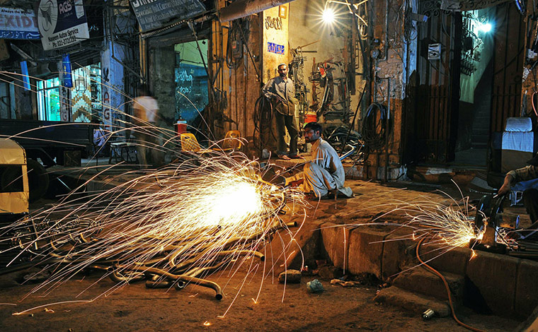 24 hours in pictures: A worker cuts metal bars for truck parts