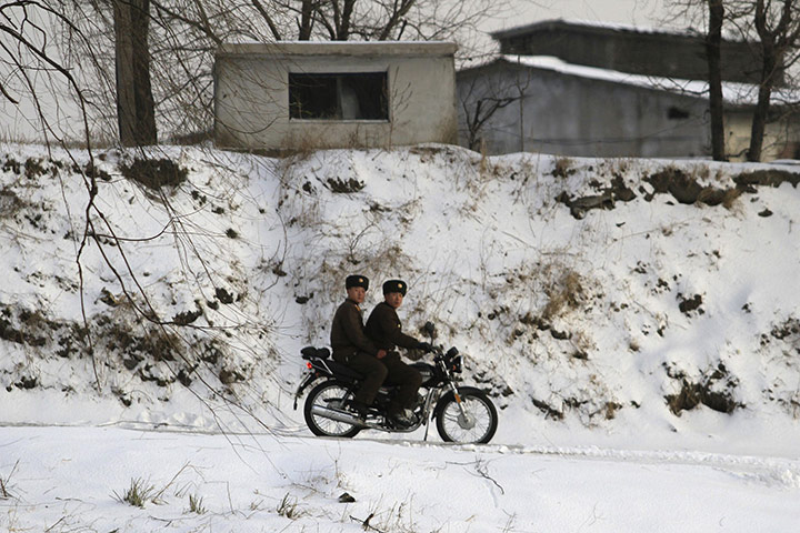 korea crisis: North Korean soldiers ride a motorcycle