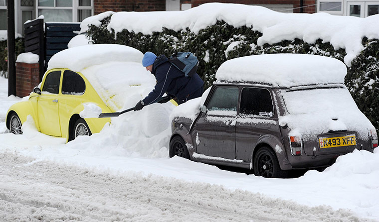 Snow and freezing hits uk: A man digs his car out in Monkseaton