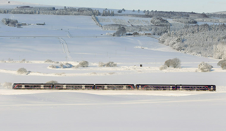 Snow and freezing hits uk: A passenger train makes its way past Greenloaning