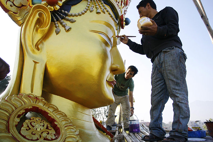 24hours in pics: Artists retouch a giant statue of Buddha
