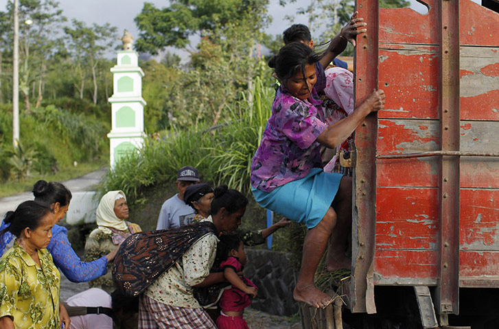 24hours in pics: A woman steps down from a truck in Sidorejo village in Klaten