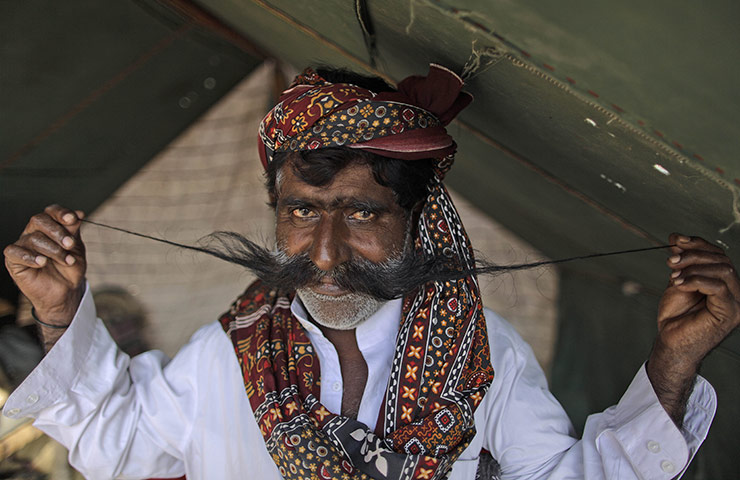 24hours in pics: Truck driver Ghulam Huseein displays his moustache at his makeshift tent