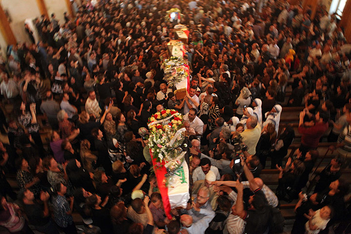 24hours in pics: Baghdad, Iraq: Mourners carry the coffins of slain Christians