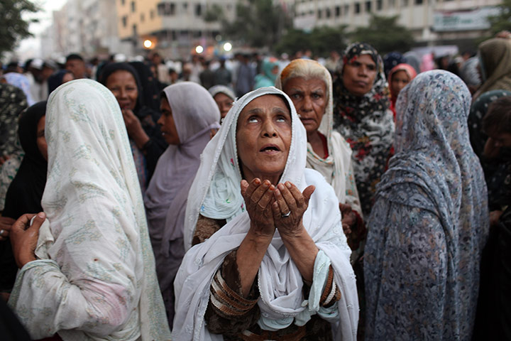 Karachi Pakistan: Women offer prayers at a rally held by the Lyari Aman (Peace) Committee