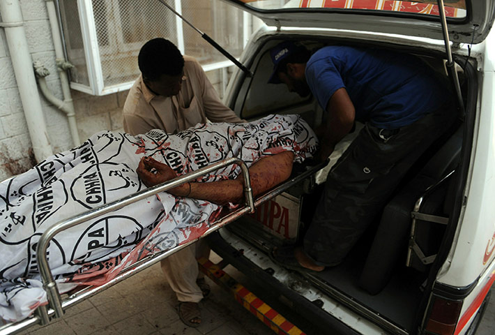Karachi Pakistan: Pakistani volunteers carry an unidentified bullet-riddled body
