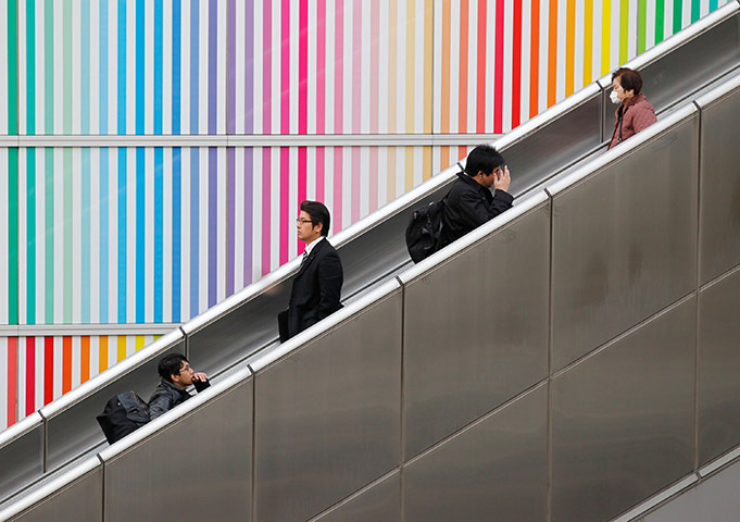 24 hours in pictures: People ride an escalator outside a railway station in Tachikawa