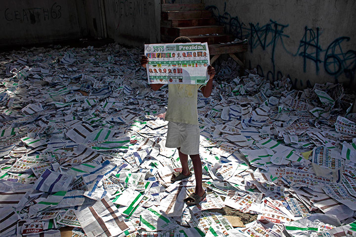 24 hours in pictures: A child holds up an unmarked election ballot, Haiti