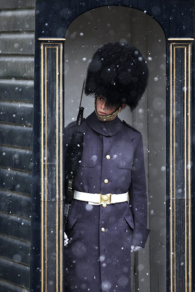 More Snow hits the UK: A soldier of the Scots Guards peers out of his sentry box 
