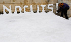 A student writes 'No Cuts' with snow in Edinburgh