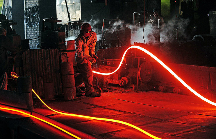 From the agencies: A Steel worker is pictured as he works with molten steel