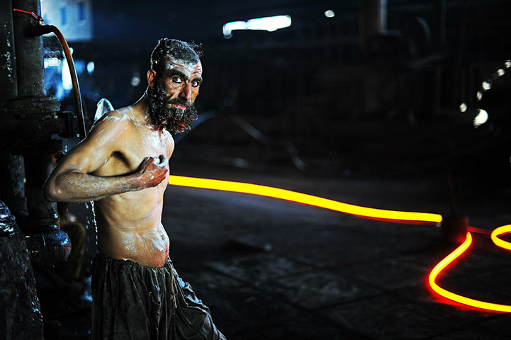 From the agencies: A steel worker is pictured as he washes