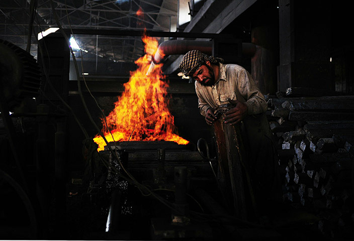 From the agencies: A steel worker is pictured in front of a furnace