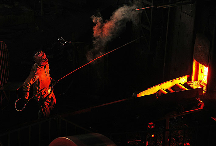 From the agencies: A steel worker removes a block of molten