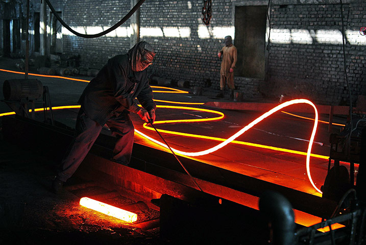 From the agencies: A steel worker works on molten steel shaping