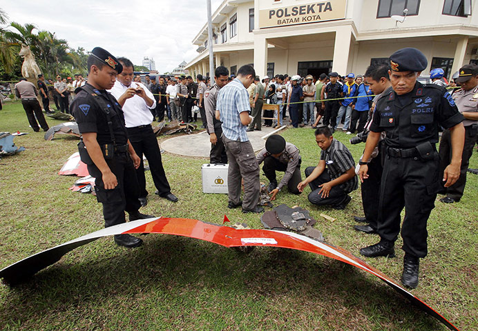 Qantas engine failed: Indonesian police officers inspect parts of a Qantas jetliner