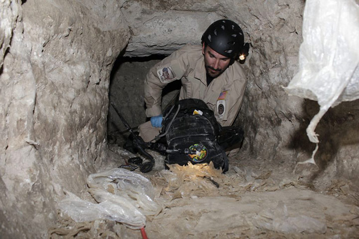 Tunnel Drug Smuggling: Federal agent crawls through a  tunnel found between USA and Mexico