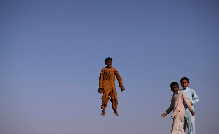 24 hours in pictures: Pakistani flood displaced boys jump on trampoline