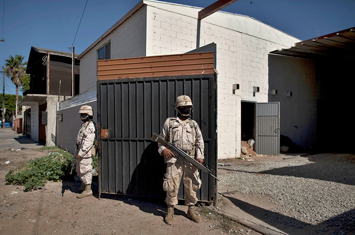 24 hours in pictures: Soldiers guard outside a warehouse where a tunnel near the US-Mexico border