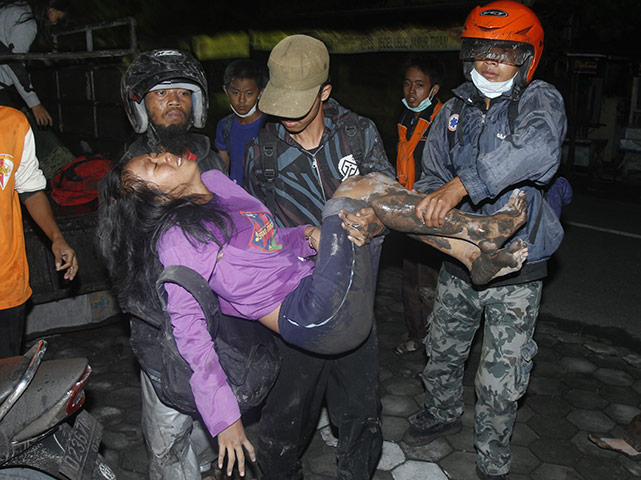 Merapi Volcano Update: Villagers carry a women as they flee their homes